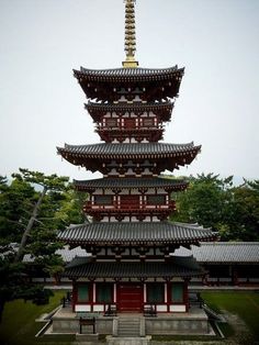 a tall pagoda in the middle of a park