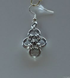 a pair of silver earrings sitting on top of a table