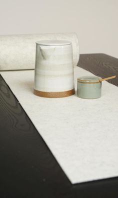 a roll of white paper sitting on top of a table next to a glass cup