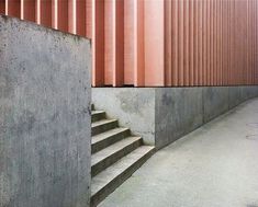 a skateboarder doing a trick on the side of a concrete wall and stairs