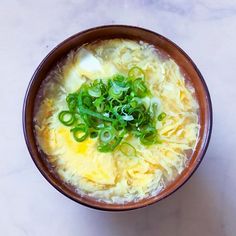 a brown bowl filled with food on top of a white counter