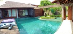 an inflatable elephant float is sitting on the edge of a pool next to a house