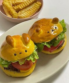 two burgers with cheese and meat on them are sitting on a plate next to some fries