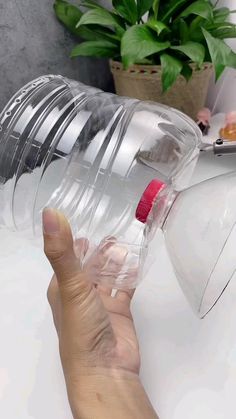 someone is holding a plastic water bottle in their left hand, with the lid partially open