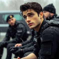 two police officers sitting in the rain on their bikes and one is holding his hand out