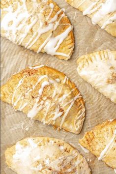 baked pastries with icing sitting on top of a baking sheet