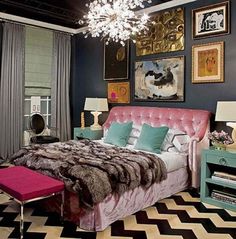 a bedroom decorated in black, white and pink with pictures on the wall above the bed