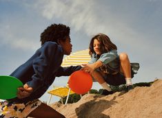 two children playing with frisbees in the sand