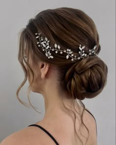 a woman wearing a bridal hair comb with leaves on it's head and pearls in her hair