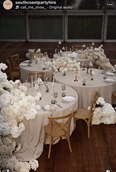 the tables are set with white flowers and candles