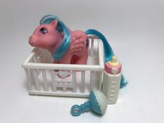 a toy horse that is laying in a crib