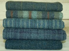 a stack of blue and green wool blankets