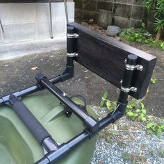 the back end of a green lawn mower with two large black handles on it