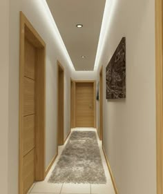 an empty hallway with wooden doors and carpeted flooring on both sides is lit by recessed lighting