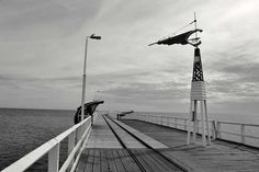 a black and white photo of a pier