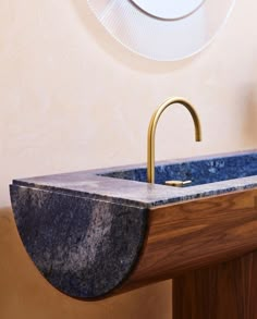 a bathroom sink with a marble counter top and brass faucet in the middle