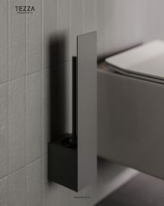 a white toilet sitting next to a wall mounted faucet