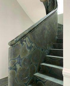 an artistic staircase with marble steps and handrails