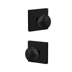 two black square knobs on a white wall and one has a round button in the middle