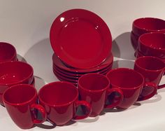 a stack of red cups and saucers sitting on top of each other