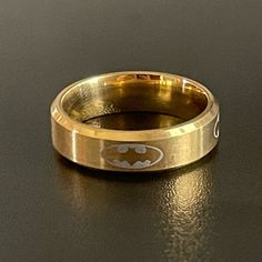 a gold batman ring sitting on top of a table