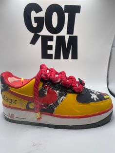 a pair of sneakers with red and yellow laces on the top, sitting in front of a white background