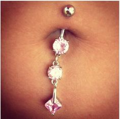 a close up of a person's belly with pink and white jewels on it