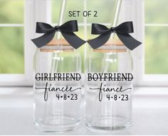 two personalized glass jars with black bows on the top and bottom, sitting next to each other