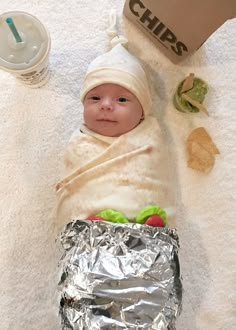 a baby wrapped in tin foil is laying on the floor