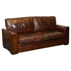 a brown leather couch sitting on top of a white floor