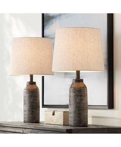 two lamps sitting on top of a wooden table