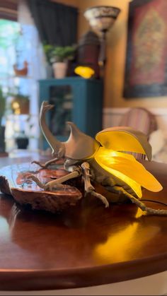 a yellow flower sitting on top of a wooden table