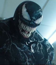 a close up of a person wearing a black suit with white teeth and fangs on his face