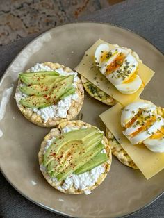 four appetizers are arranged on a plate with cheese and an avocado