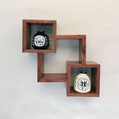 three wooden shelves with two vases on each shelf and one has a black and white design