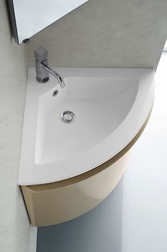 a bathroom sink sitting under a mirror next to a wall mounted faucet on the side of a white counter