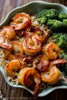 shrimp, broccoli and rice in a bowl on top of a wooden table