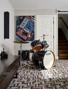 a drum kit sits on the floor in front of a staircase