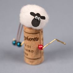 there is a cork with a sheep on it and some beads in the top one