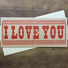 i love you sticker on top of two envelopes sitting on a wooden table