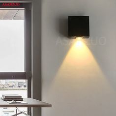 a wall light that is on the side of a wall next to a table and window