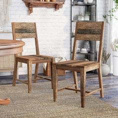 two wooden chairs sitting next to each other on a rug