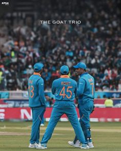 three men in blue uniforms standing on a field with their backs turned to the camera