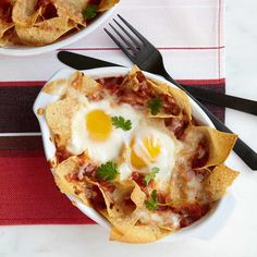 two bowls filled with nachos and eggs on top of a striped table cloth