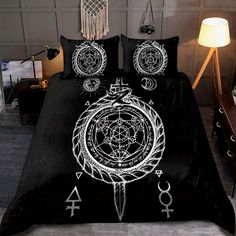 a bed covered in black and white sheets with an image of a circle, compass, and other symbols on it