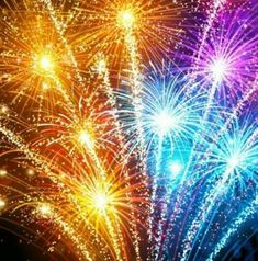 colorful fireworks in the night sky with bright colors and sparkles on it's side