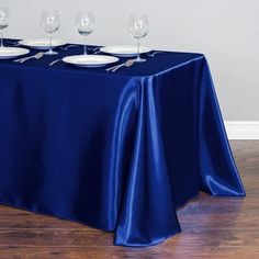 the table is set with four empty wine glasses