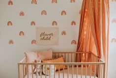 a baby's room with a crib and wallpaper