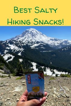 someone holding up a snack in front of a mountain with the words best salty hiking snacks