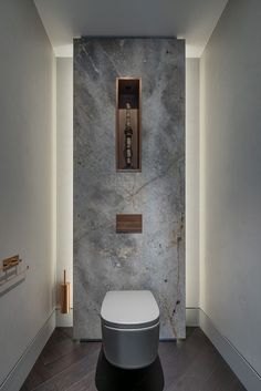 a bathroom with a toilet and some lights on the wall next to it's walls